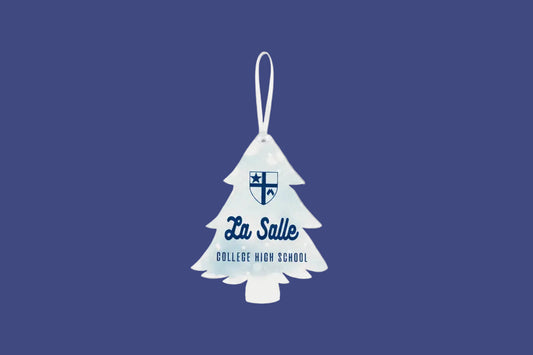 A La Salle College High School Christmas ornament shaped like a Christmas tree, featuring the school's shield logo and name in navy blue on a white background, shown on a wooden surface.